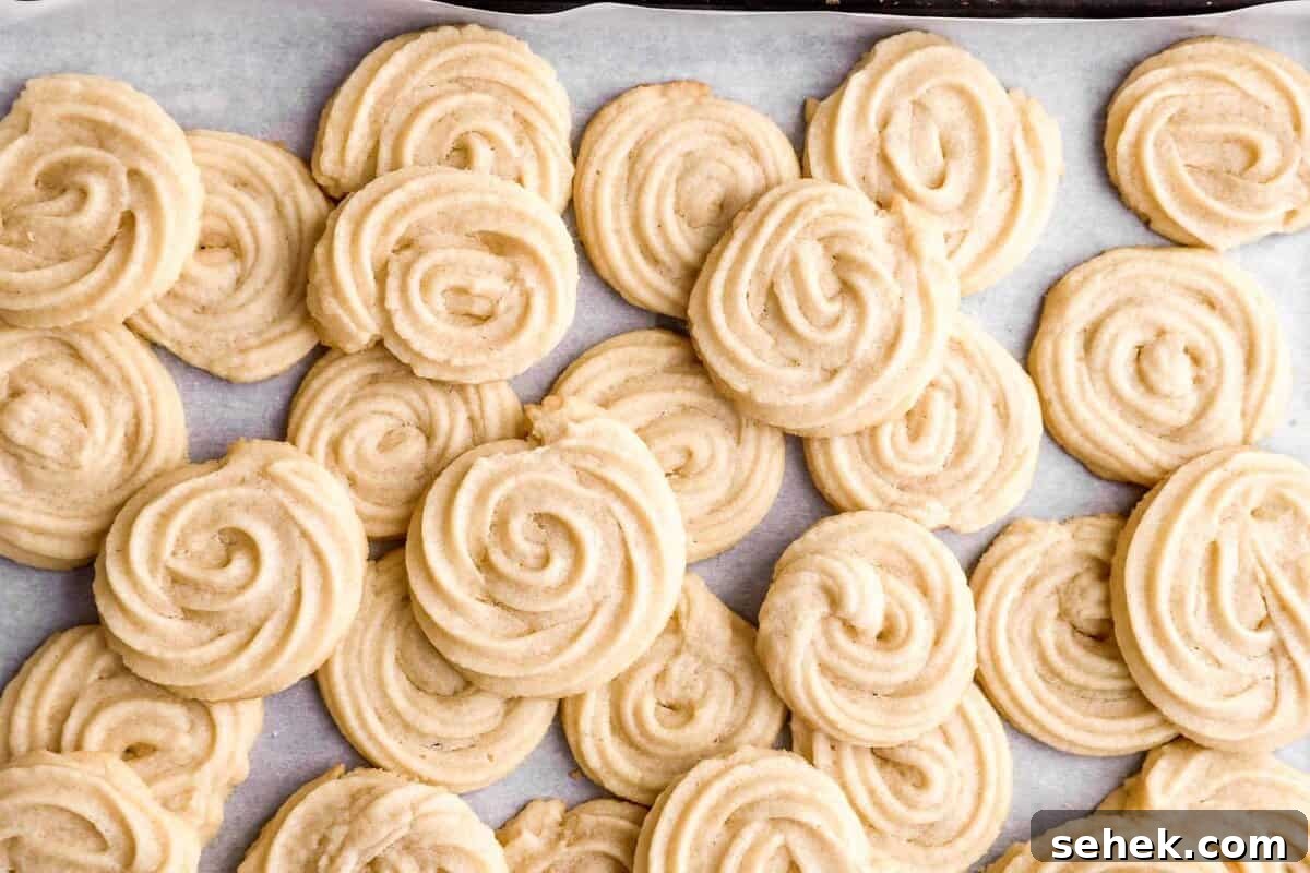 Classic Homemade Butter Cookies Recipe for Crisp, Melt-in-Your-Mouth Cookies 3 Butter cookies piled up on a baking sheet.