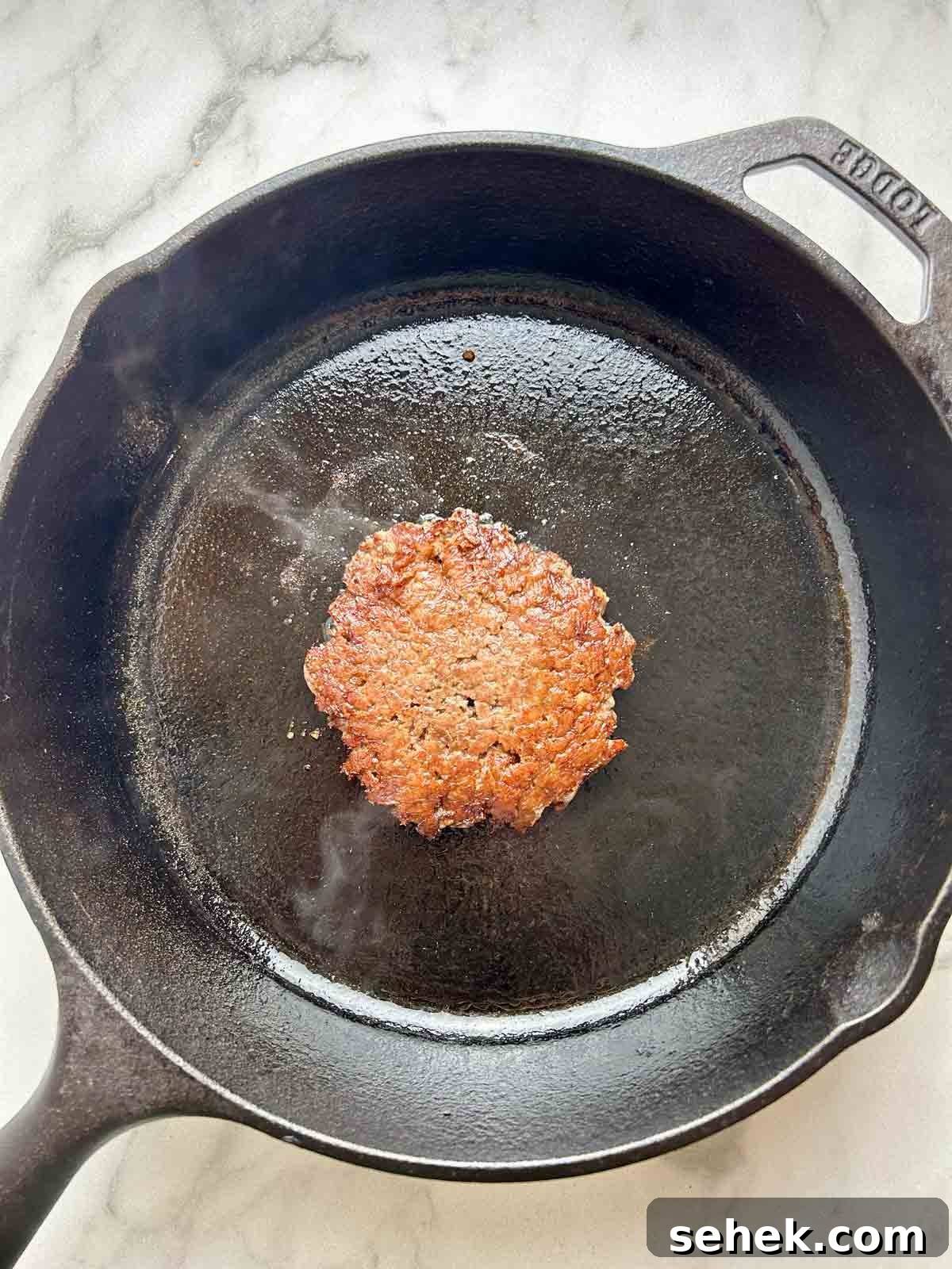 cooked patty on cast iron pan