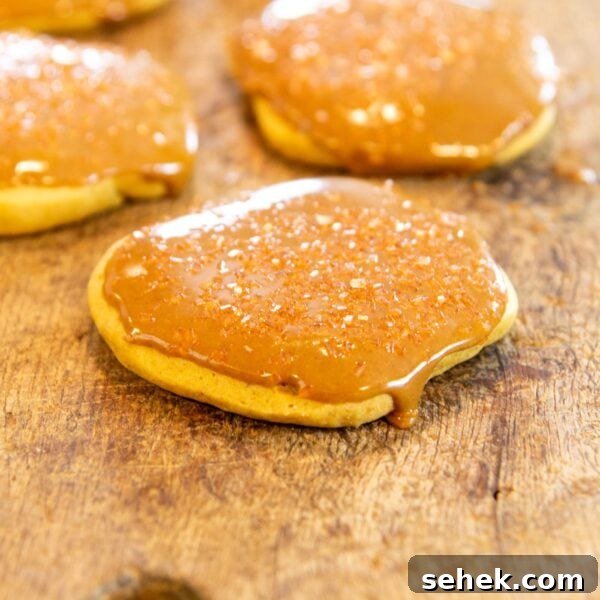 No-Bake Pumpkin Refrigerator Cookies Recipe for Fall Treats 5 A cookie with a glaze sits on a wooden board.