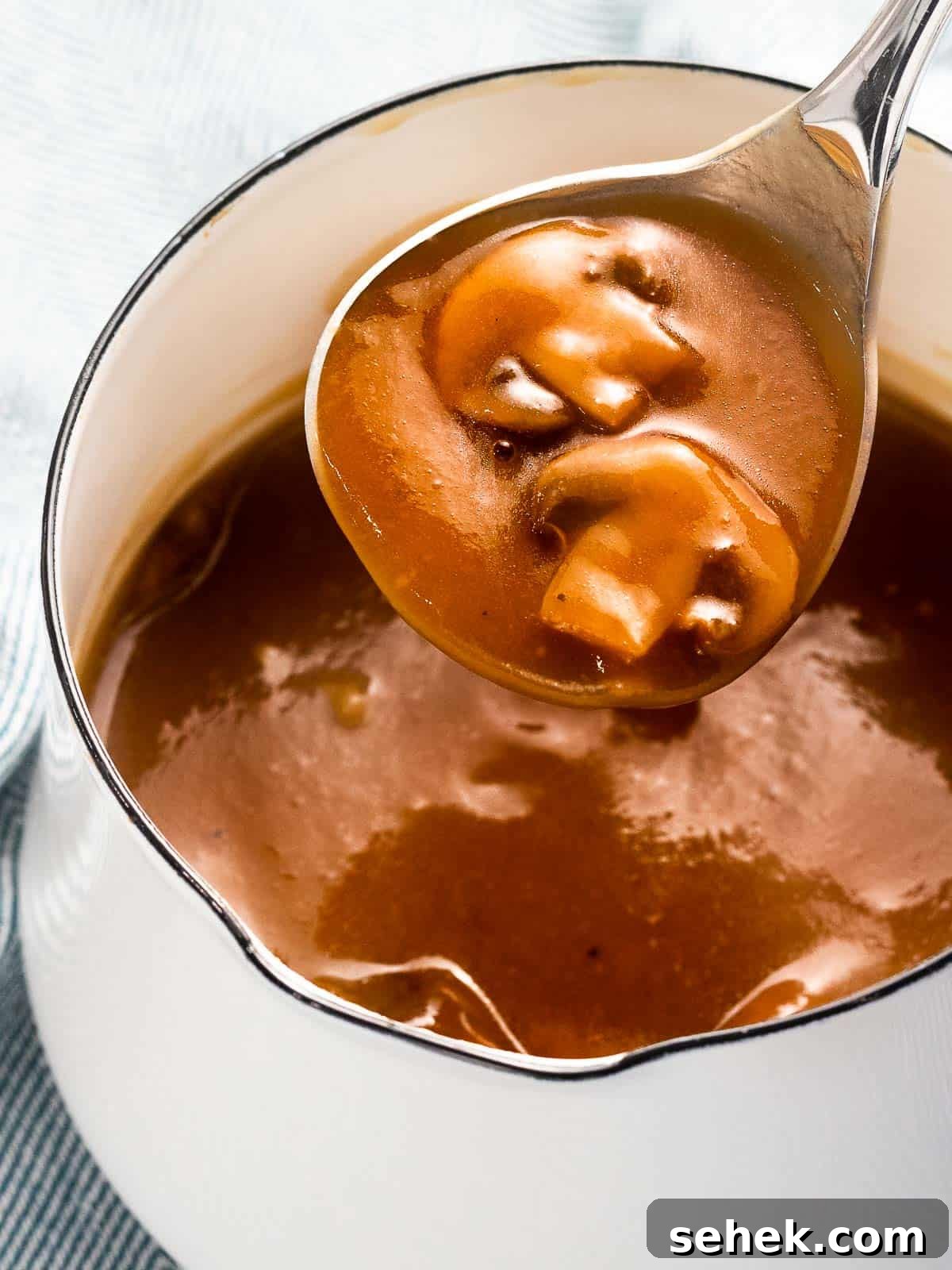 Creamy Mushroom Gravy Recipe for Steaks and Mashed Potatoes 2 Mushroom gravy with sautéed mushrooms in a pot.