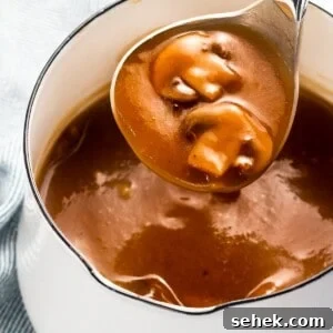 Creamy Mushroom Gravy Recipe for Steaks and Mashed Potatoes 7 Mushroom gravy with sautéed mushrooms in a ladle.