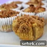 Fluffy Apple Cinnamon Muffins with Streusel Topping 15 Apple crumb muffin on a white plate.