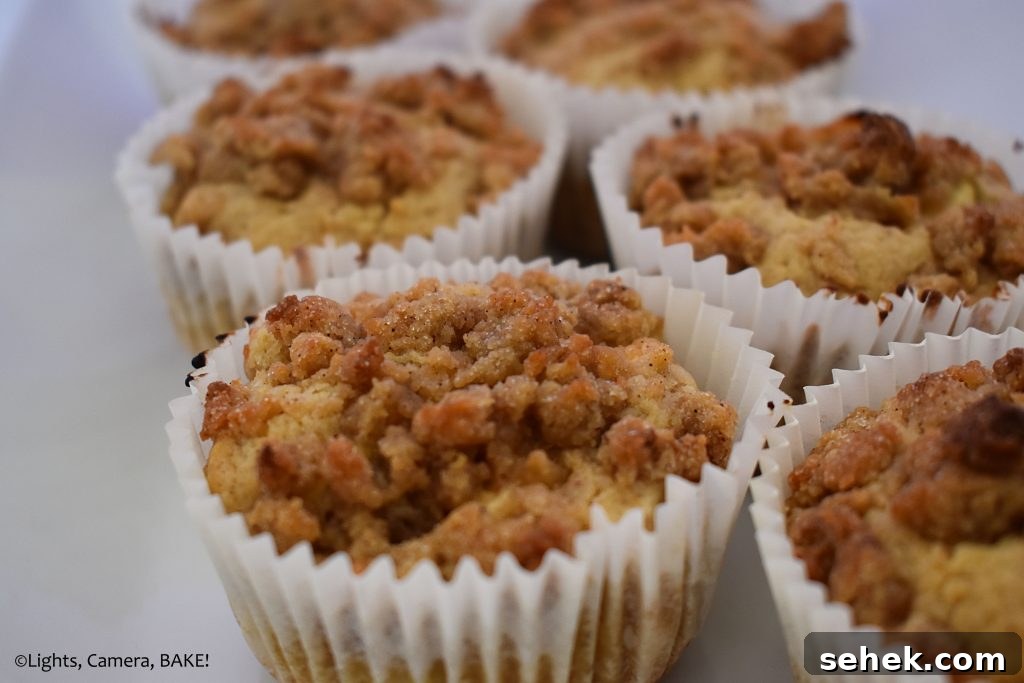 Fluffy Apple Cinnamon Muffins with Streusel Topping 3 Crumb muffin on a white plate.