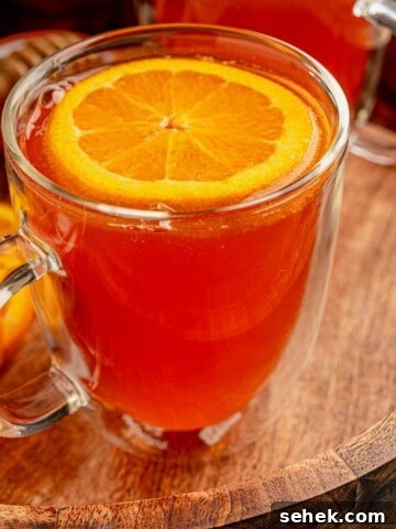 A warm cocktail in a clear mug.
