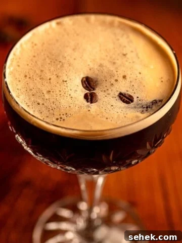 An espresso martini topped with coffee beans.