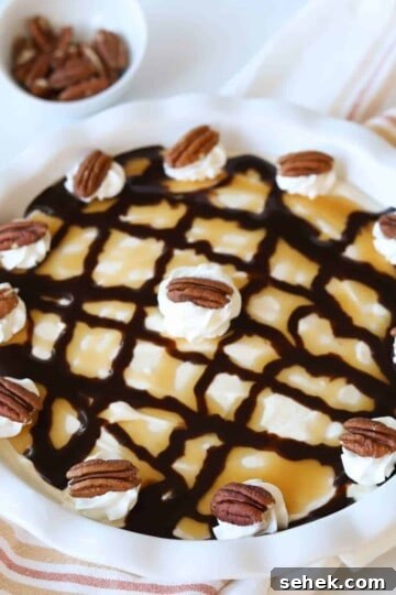 Turtle pie topped with whipped cream and pecans.