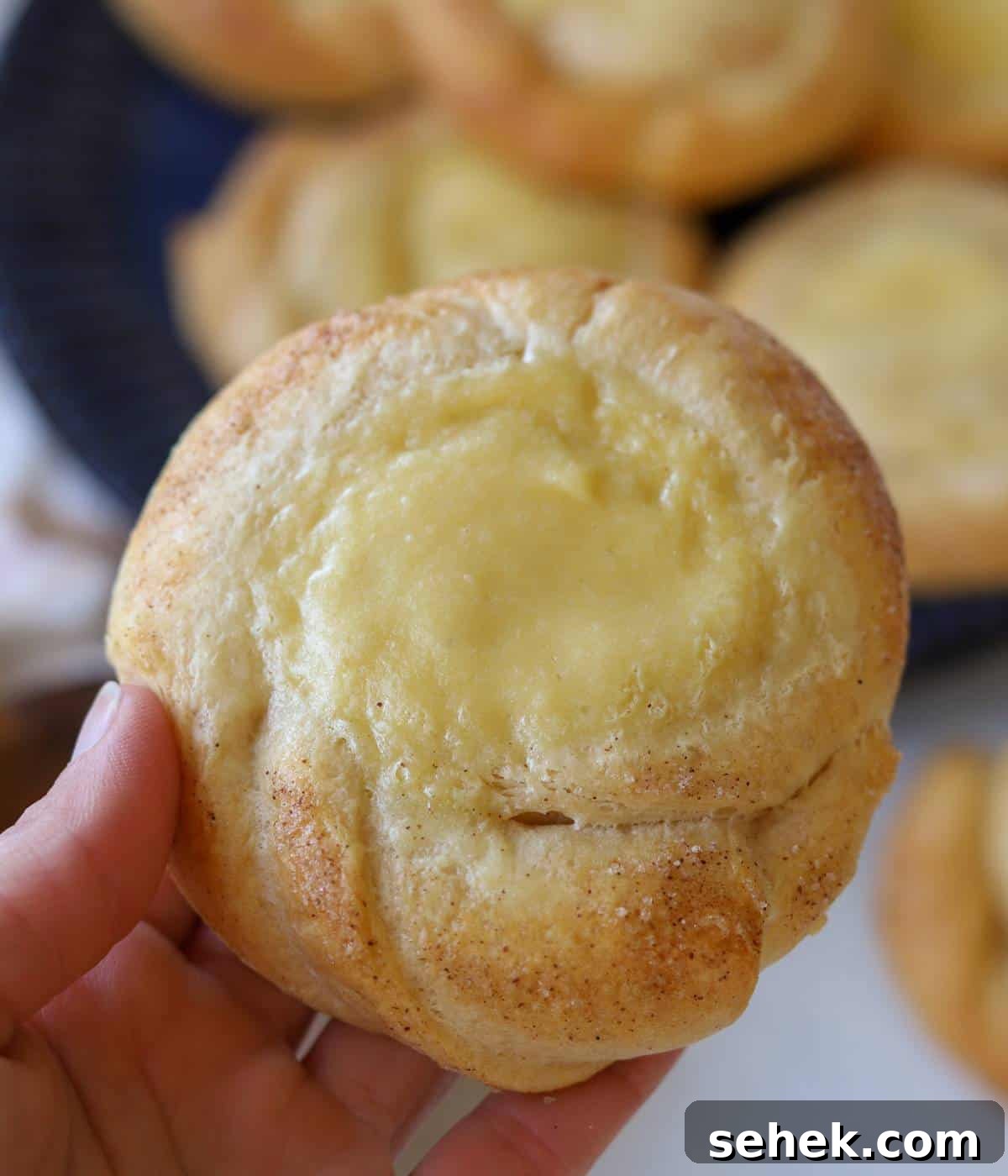 Hand holding cream cheese danish.