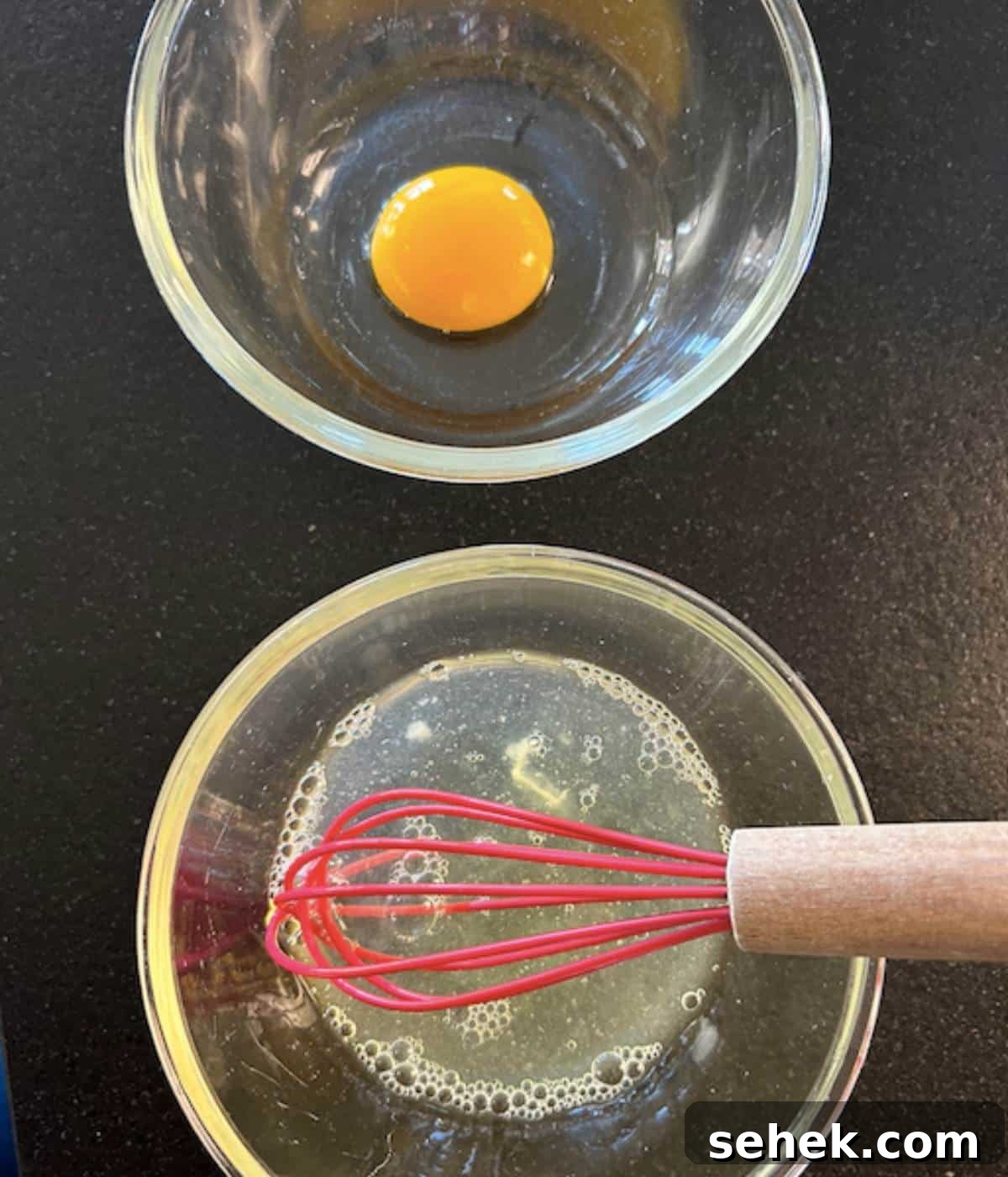 Egg yolk separated from egg white in two bowls.