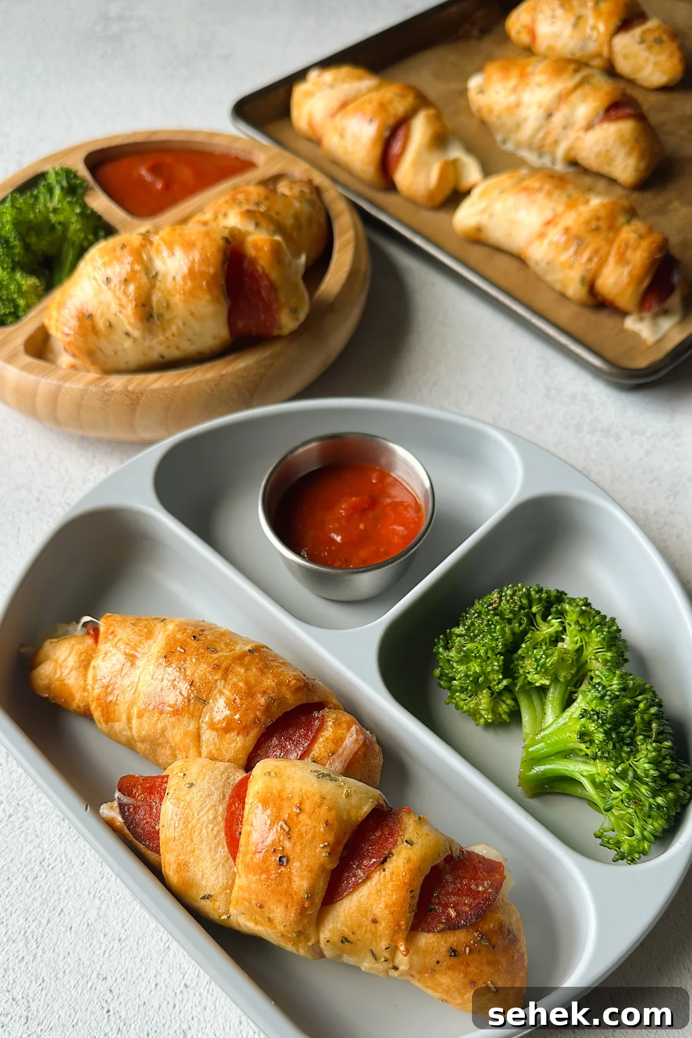 Crescent-Style Pizza Rolls: Gooey Pepperoni Bites Recipe 2 Crescent pizza rolls served with broccoli and marinara sauce.