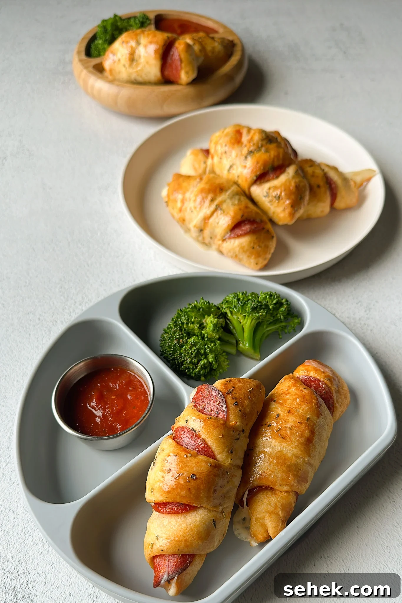 Crescent-Style Pizza Rolls: Gooey Pepperoni Bites Recipe 7 Crescent pizza rolls served with broccoli and marinara sauce.