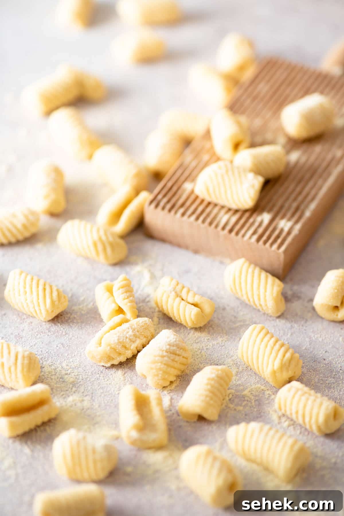 How to Make Gnocchetti Sardi (Malloreddus) — Authentic Sardinian Recipe 2 Gnochetti Sardi on a work surface with a gnocchi board