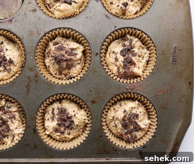 Greek Yogurt Chocolate Chip Muffins — Moist, Protein-Packed Recipe 8 Unbaked muffins in a muffin tin.