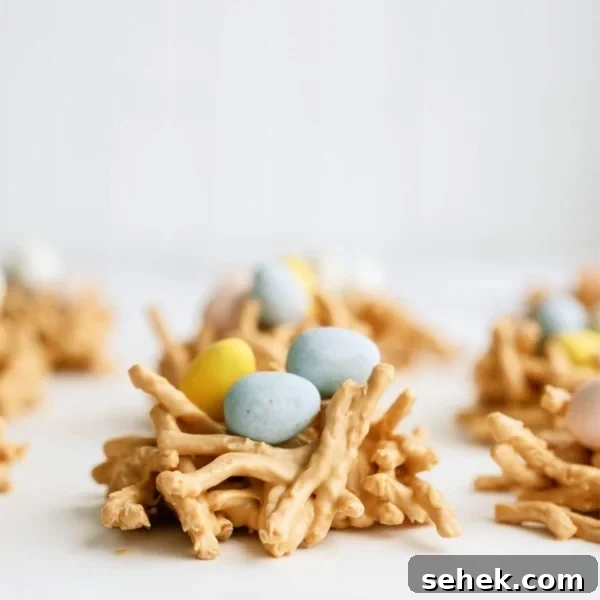 A close up of a Chow Mein Butterscotch Birds Nest Treat topped with chocolate mini eggs, with other nests in the background.
