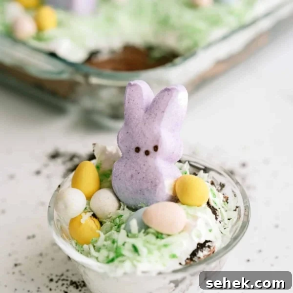 A serving of Easter Bunny Pudding Dirt Cake in a small plastic cup.
