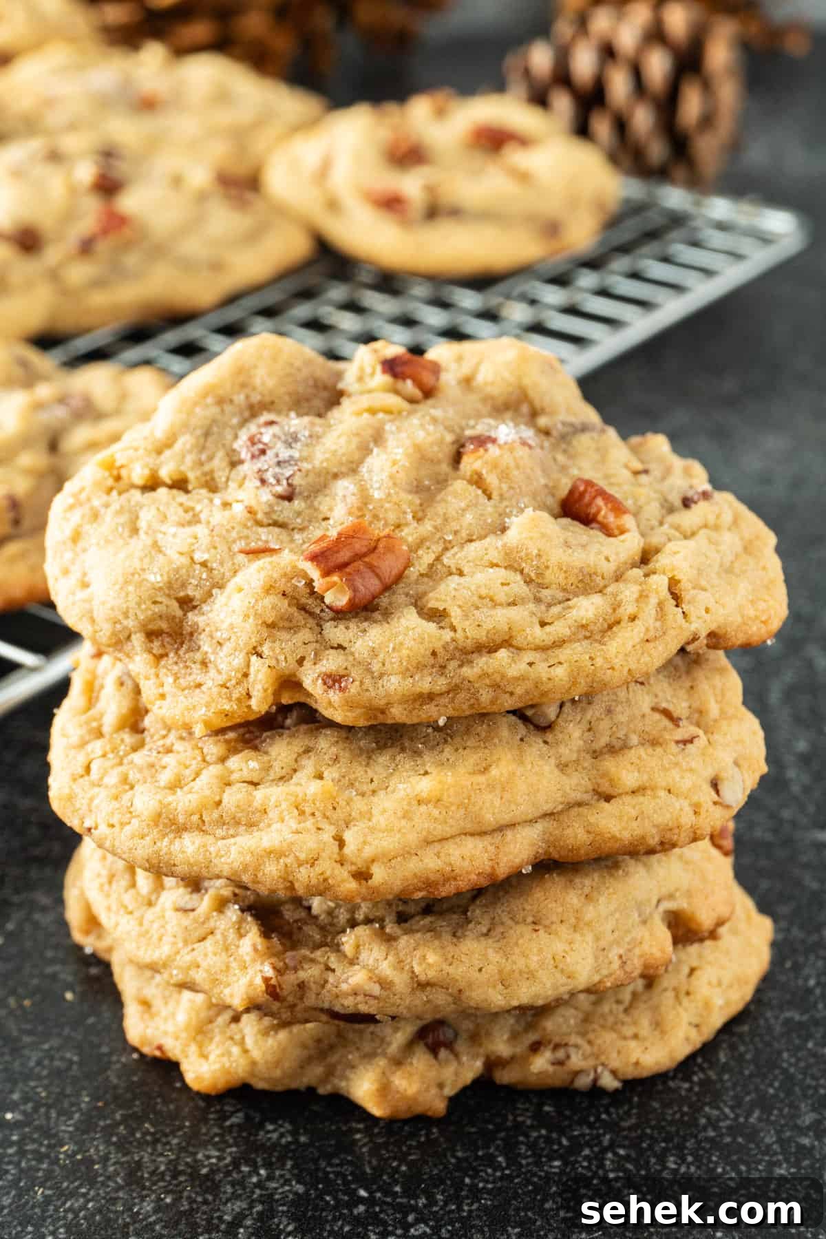 Pecan Pie Cookies: Chewy Cinnamon-Pecan Cookie Recipe 3 pecan pie cookies stacked 3 high with more cookies in the background.