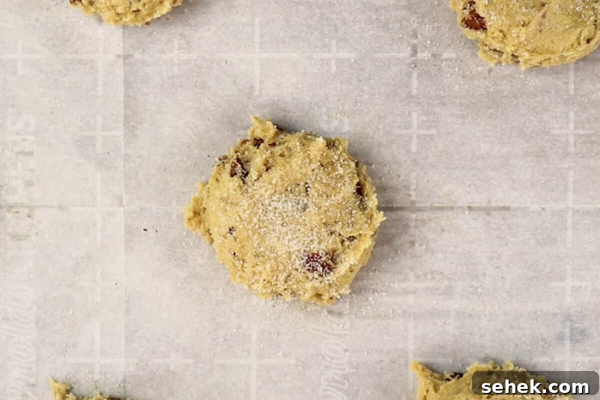 Pecan Pie Cookies: Chewy Cinnamon-Pecan Cookie Recipe 10 Sprinkling raw sugar on scooped cookie dough on a baking sheet.