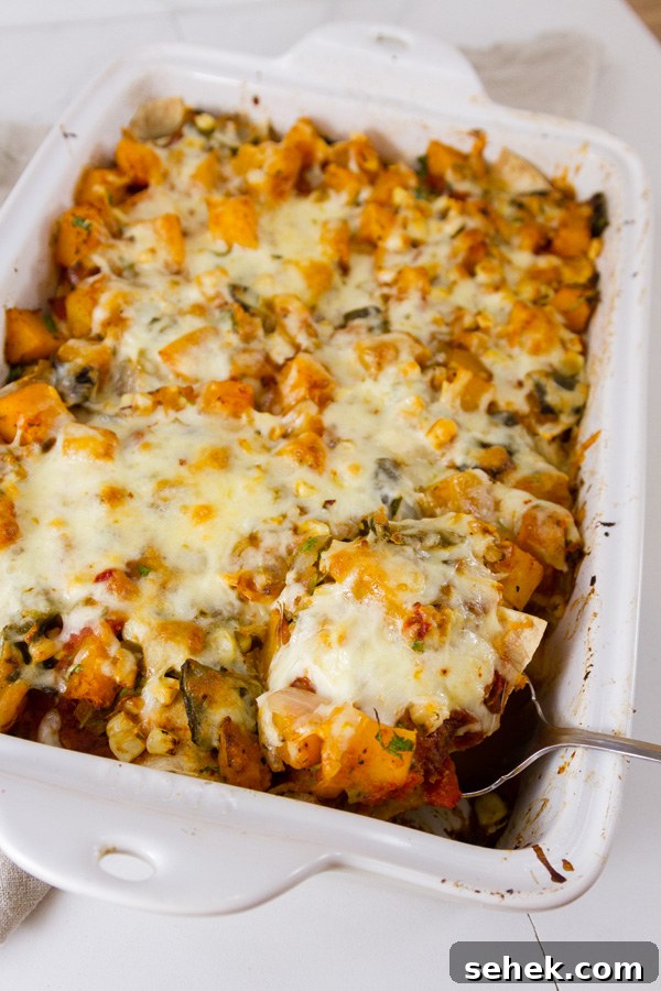 Mexican-Style Butternut Squash Casserole with Chipotle and Cheese 7 Mexican casserole in a pan with a serving beging taken out