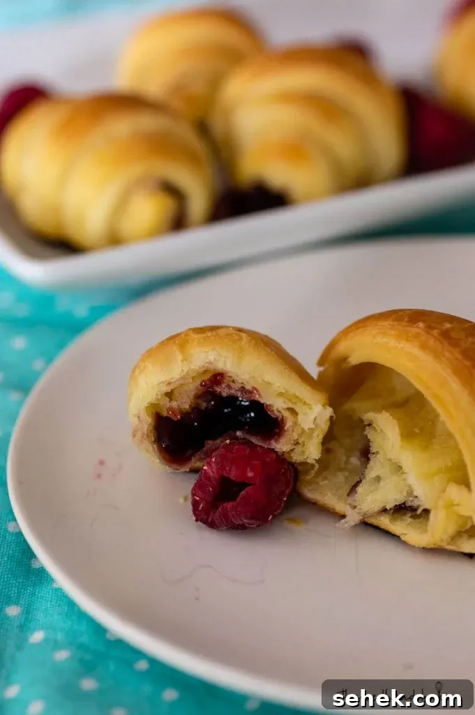 Raspberry Brioche Crescent Pastries: Flaky, Buttery Treats 7 A raspberry brioche crescent broken in half to reveal the raspberry filling