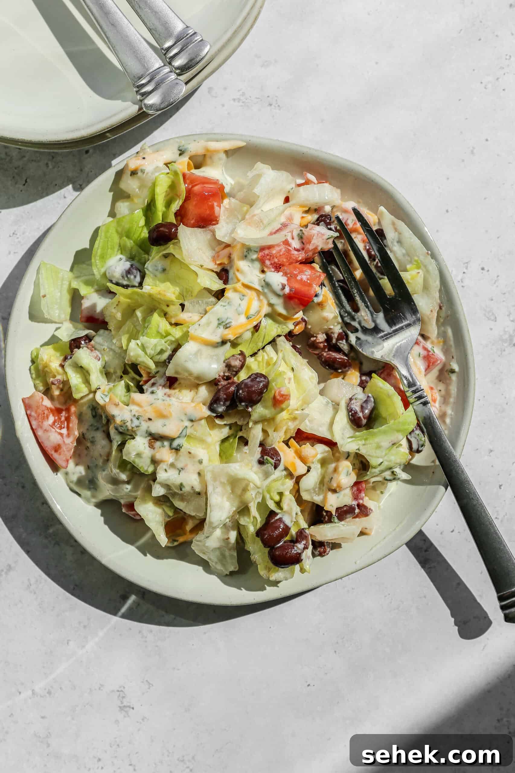 Layered Chopped Wedge Salad with Creamy Dressing 3 a white plate of chopped wedge layer salad.