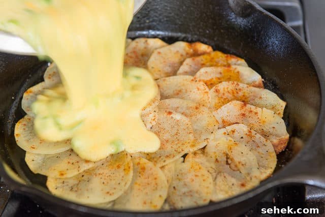 Crispy Potato Frittata with Caramelized Onions and Herbs 6 Pouring Egg Potato Frittata Batter in Cast Iron Skillet