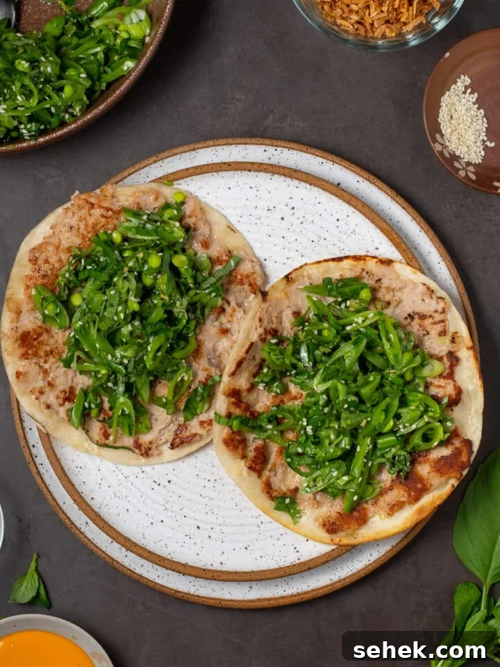 two tacos with a ahi tuna layer and a bright green fresh snap pea and herb salad inside