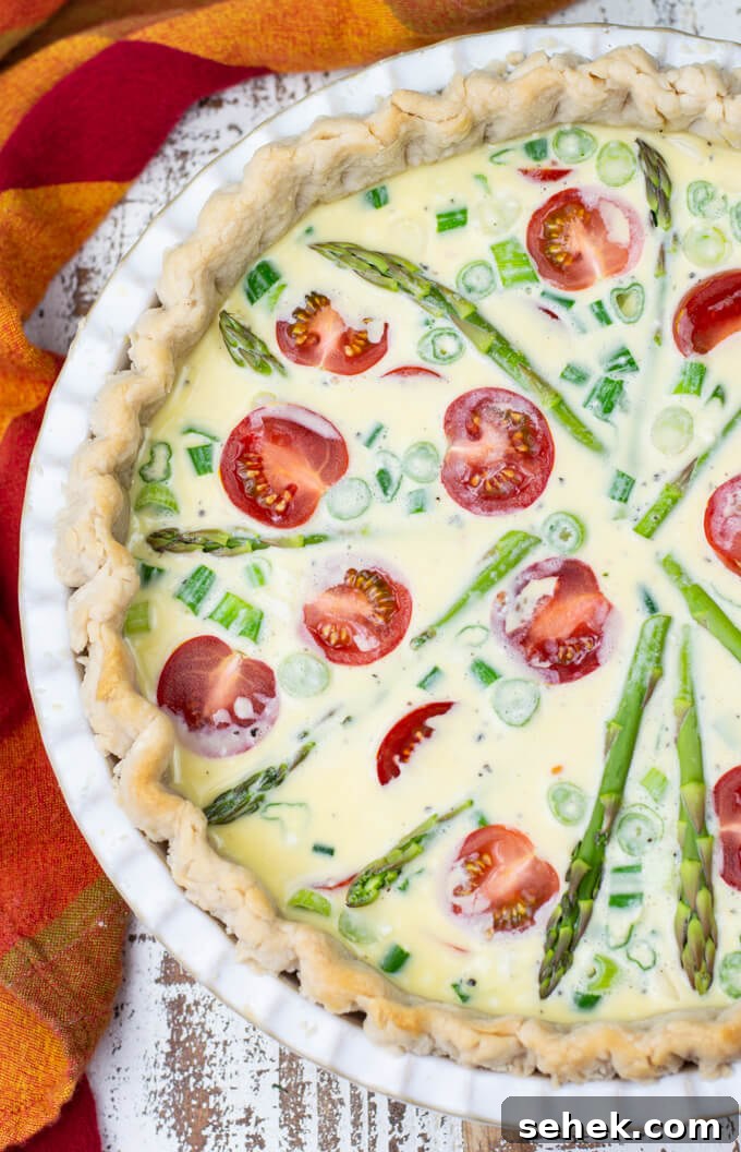 Asparagus and Cherry Tomato Quiche Recipe for Spring Brunch 5 An unbaked quiche with asparagus spears and cherry tomatoes.