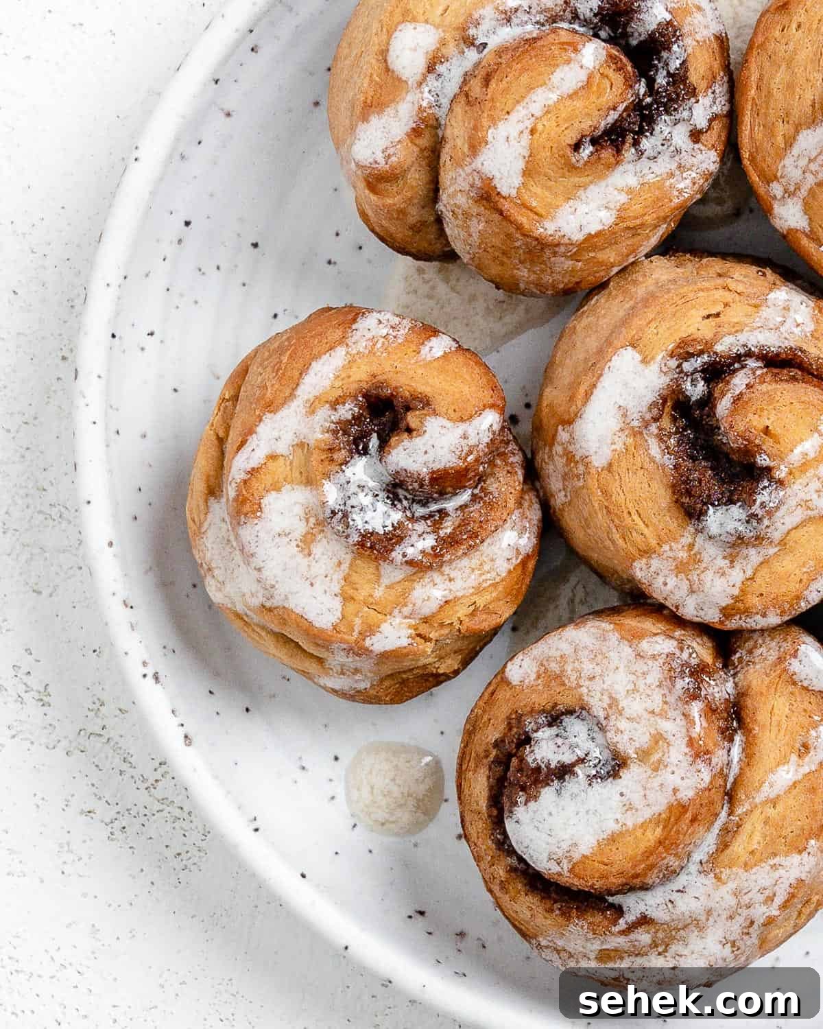 Quick Crescent Roll Cinnamon Buns: 20-Minute Sticky Rolls 16 completed Cinnamon Rolls plated against a white surface
