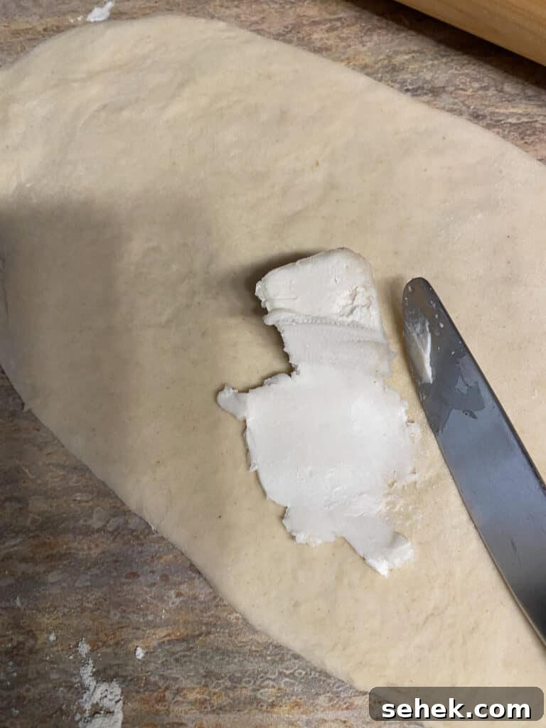 Quick Crescent Roll Cinnamon Buns: 20-Minute Sticky Rolls 6 process shot showing the spreading of vegan margarine on dough