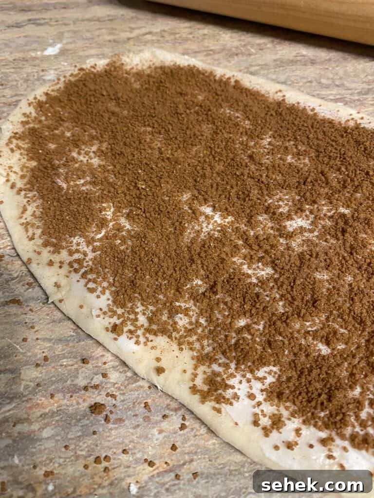 Quick Crescent Roll Cinnamon Buns: 20-Minute Sticky Rolls 9 process shot showing addition of cinnamon mixture on dough