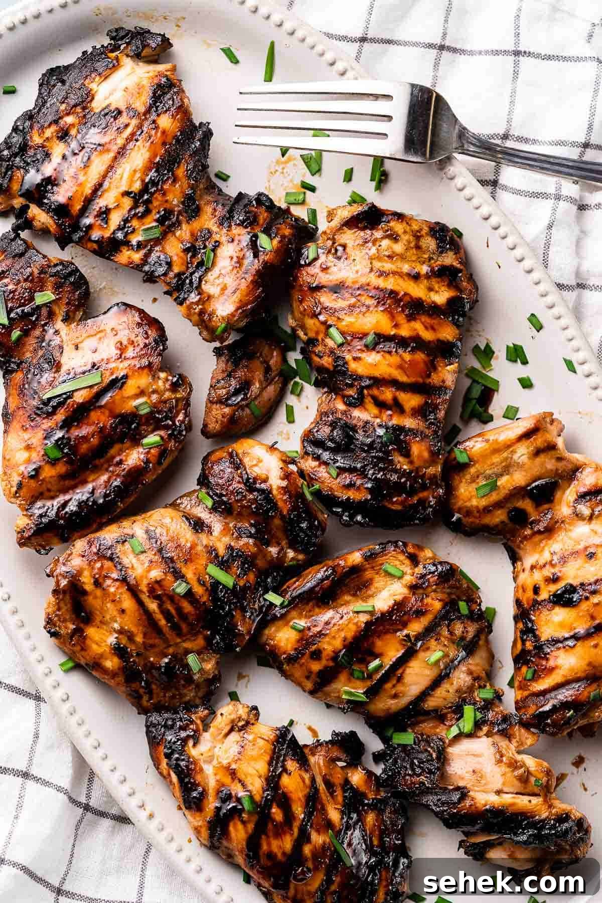 Balsamic Grilled Chicken with Garlic and Herbs 11 grilled balsamic chicken on white platter with fork on the side