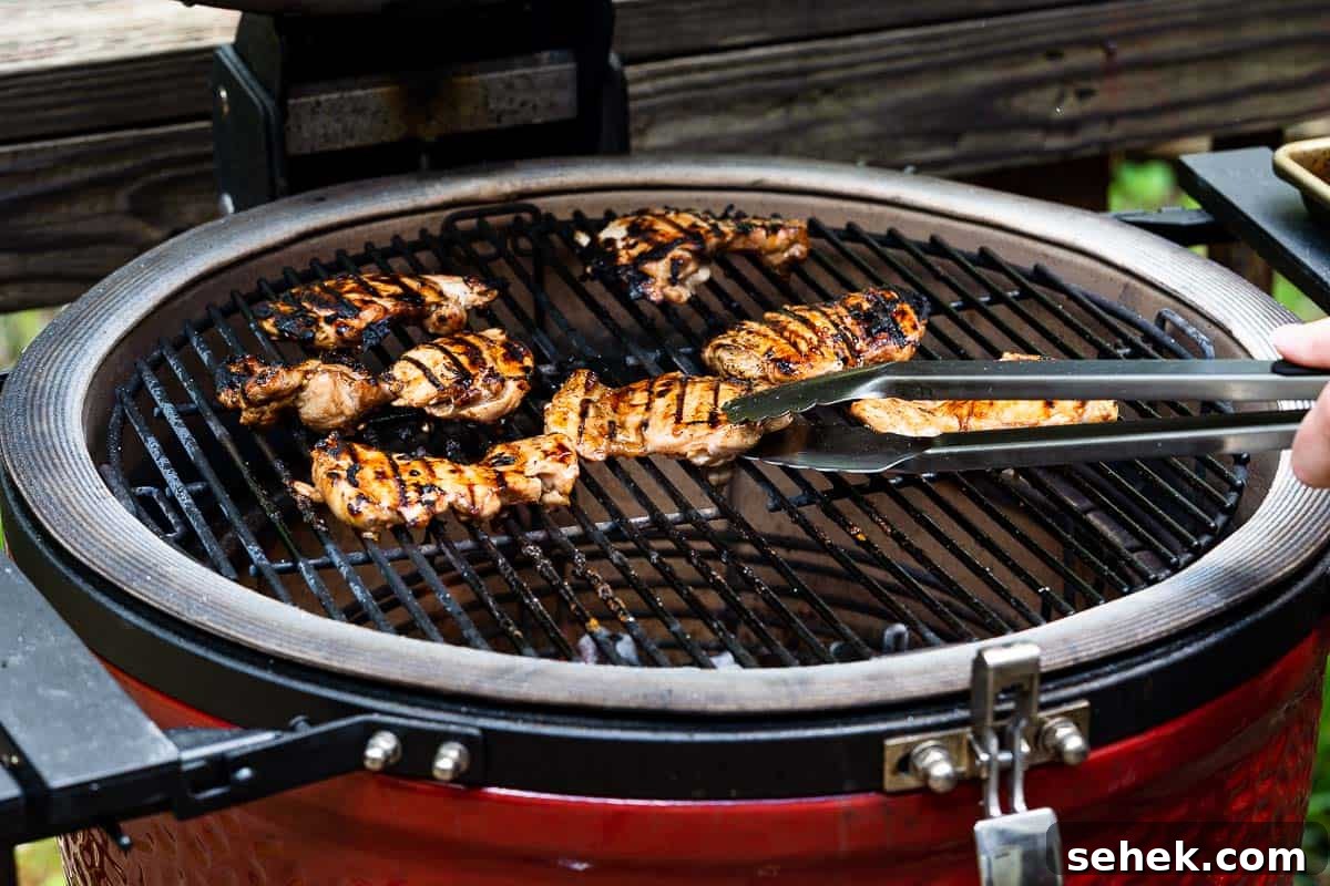 Balsamic Grilled Chicken with Garlic and Herbs 10 tongs flipping chicken on grill