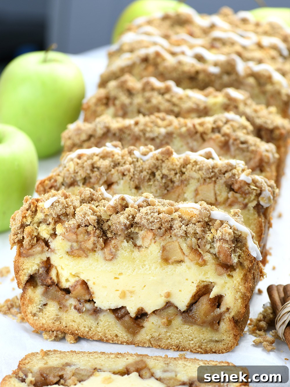 Apple Crisp Cheesecake Bread Recipe — Decadent Fall Dessert 4 Coupe of Apple Crisp Cheesecake Bread slices rounded with green apples.