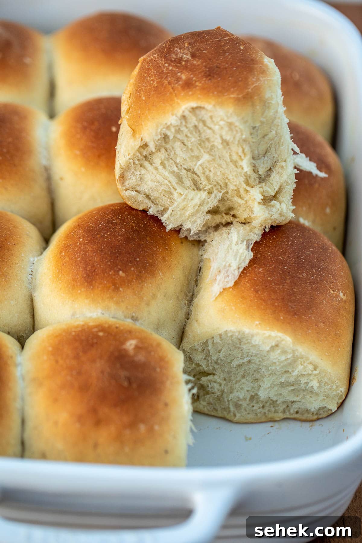 Banana Bread Rolls Recipe: Soft, Cinnamon-Swirled Breakfast Buns 2 Banana bread rolls in pan with one bread roll on top showing fluffiness