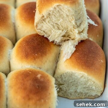 Banana Bread Rolls Recipe: Soft, Cinnamon-Swirled Breakfast Buns 8 Rolls in a pan with one roll on top to show fluffiness