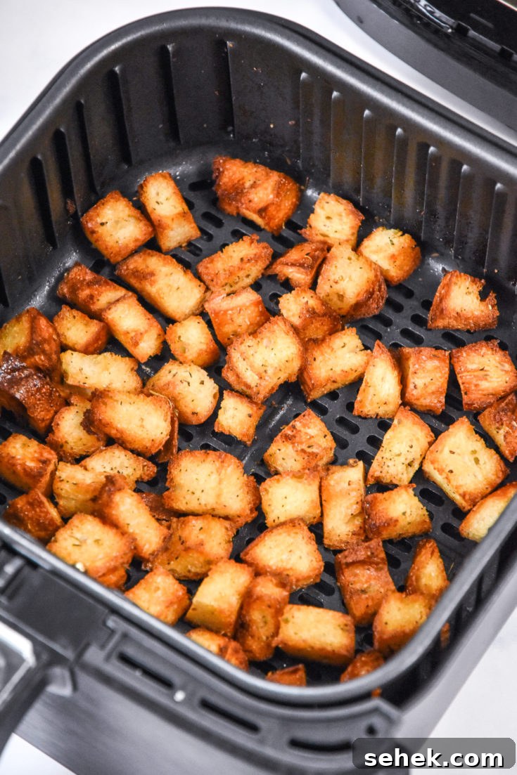 homemade croutons in an air fryer basket.
