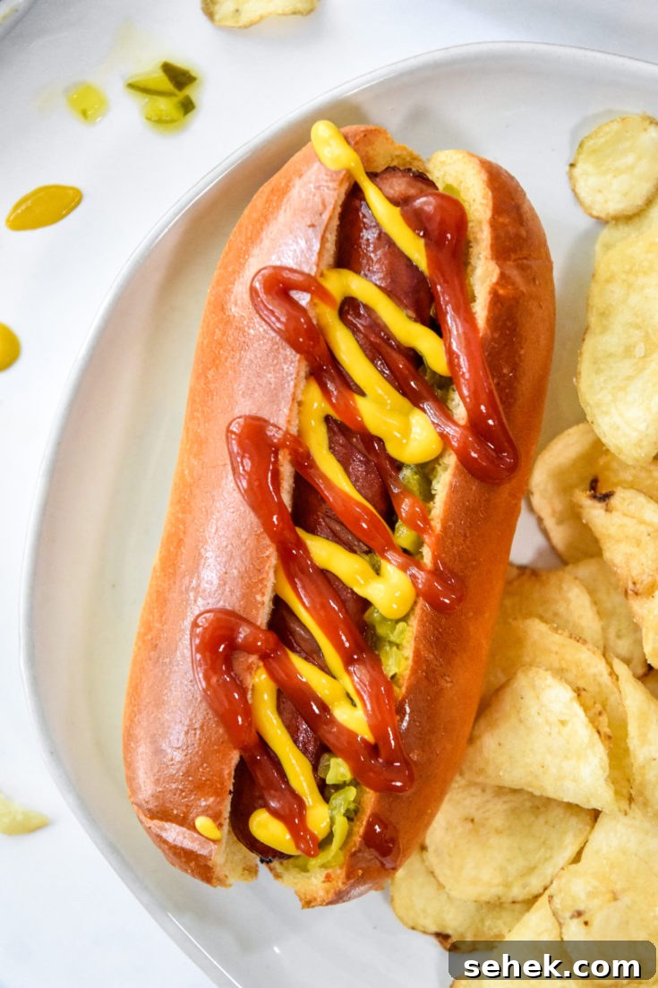 air fryer hot dogs with ketchup and mustard served with chips.