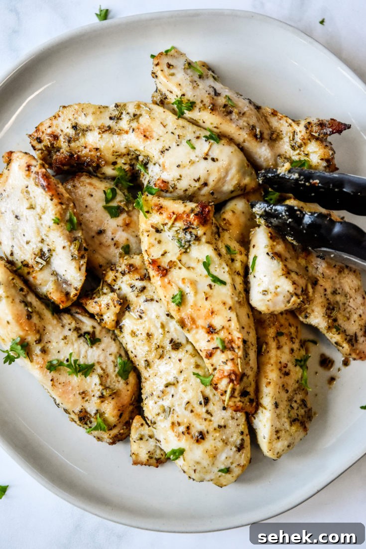 a plate of air fryer chicken tenders with tongs on the side.