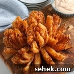 Crispy Air Fryer Blooming Onion Recipe for Perfect Appetizers 13 crispy air fryer blooming onion on a wood cutting board.