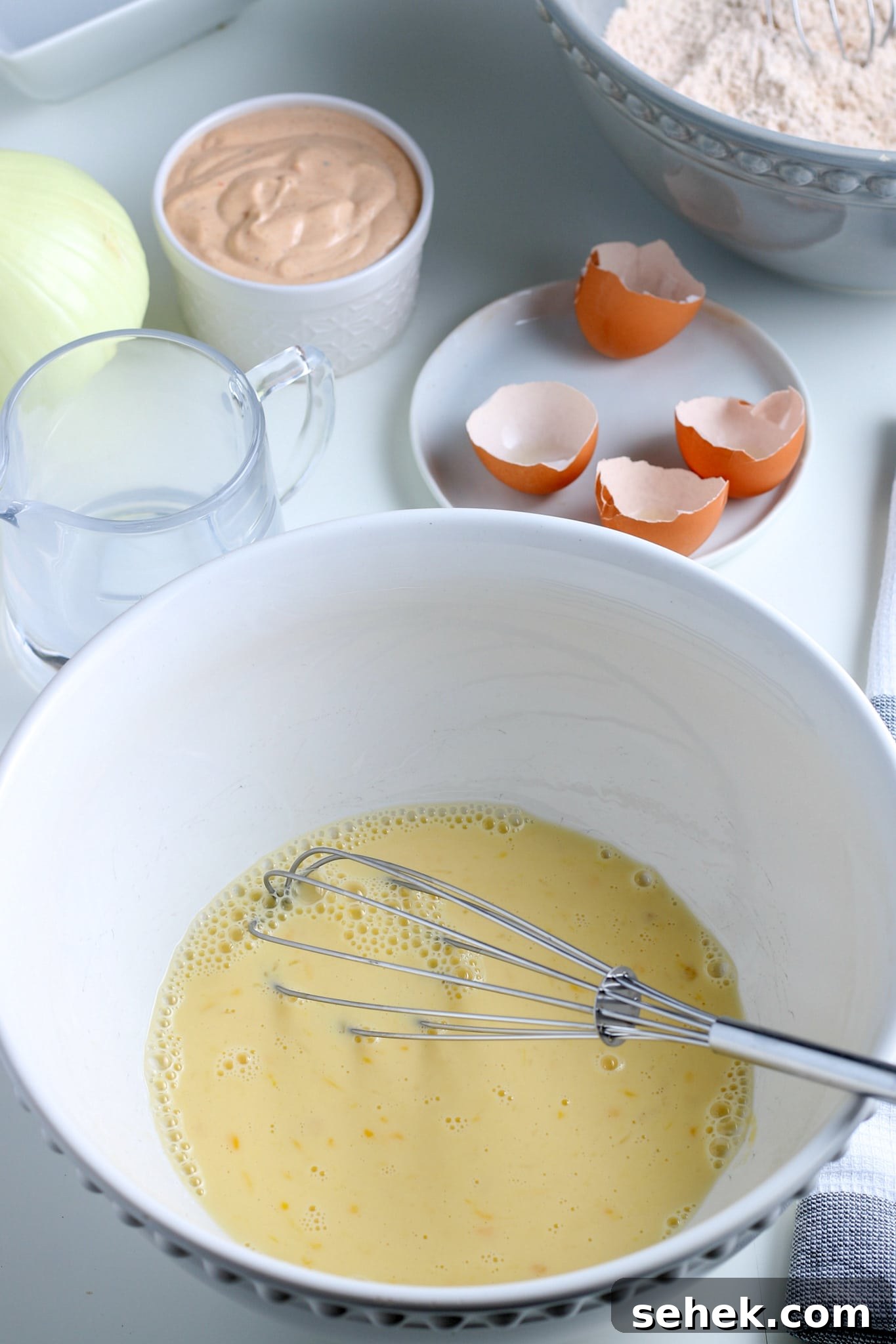 Crispy Air Fryer Blooming Onion Recipe for Perfect Appetizers 9 egg, water, and milk in a large bowl.