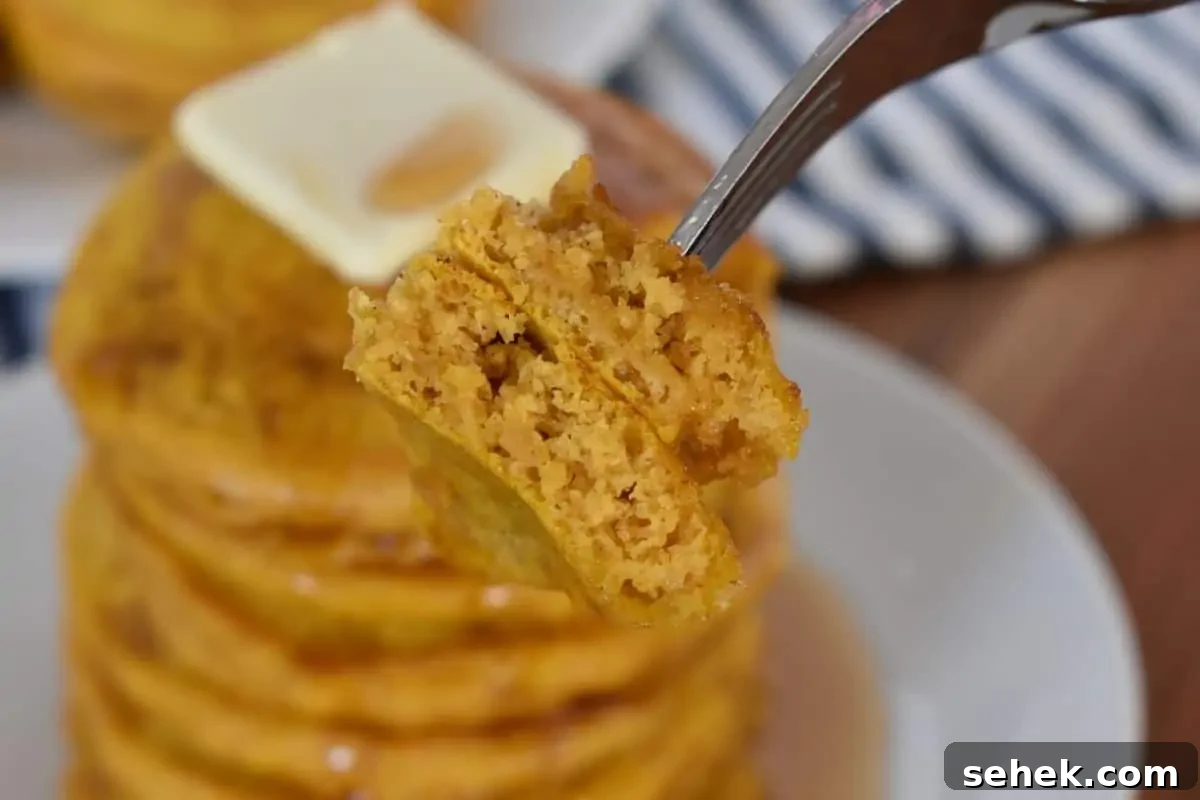 Fluffy Pumpkin Pancakes Using Pancake Mix – Quick Fall Recipe 3 Fork holding pumpkin pancakes.