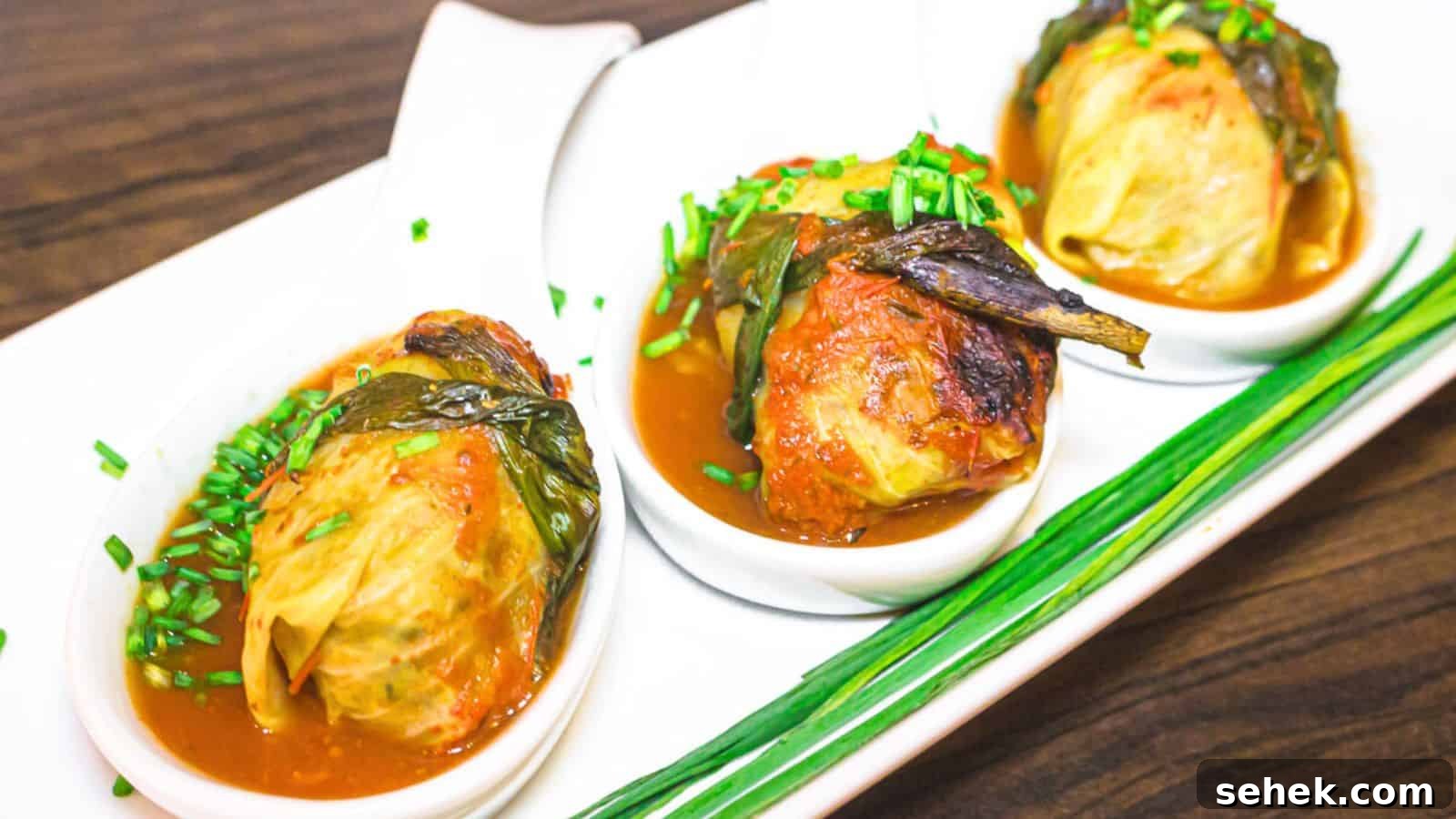 17 Cozy Casseroles for Any Night of the Week 20 Three plates of cabbage rolls with sauce on a white plate.