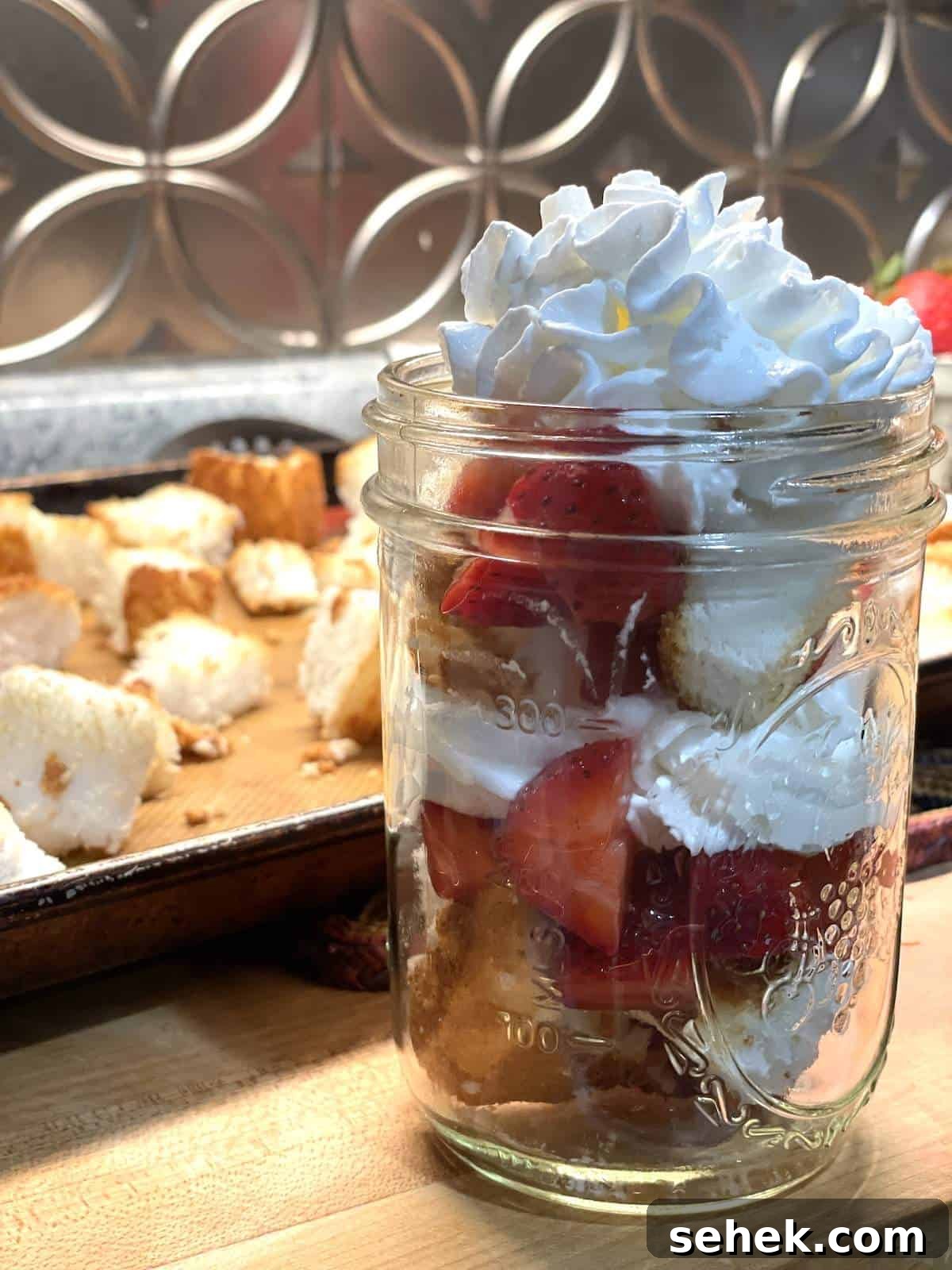 Strawberry Angel Food Shortcake with Fresh Whipped Cream 13 A jar of layers of angel food cake strawberry shortcake in a mason jar.