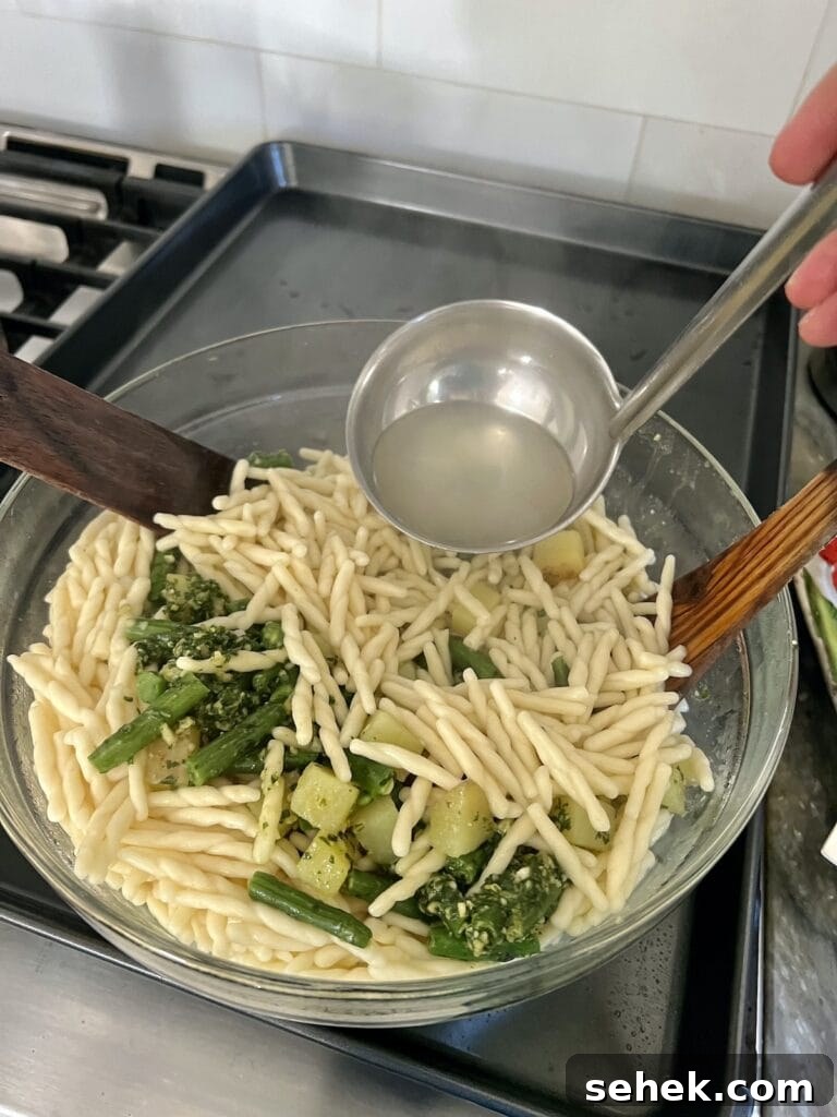 Trofie al Pesto Genovese with Potatoes and Green Beans 12 Adding some pasta water to the trofie al pesto genovese.
