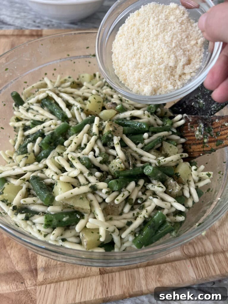 Trofie al Pesto Genovese with Potatoes and Green Beans 13 Adding grated cheese to the Pasta with Pesto Green Beans and Potatoes.