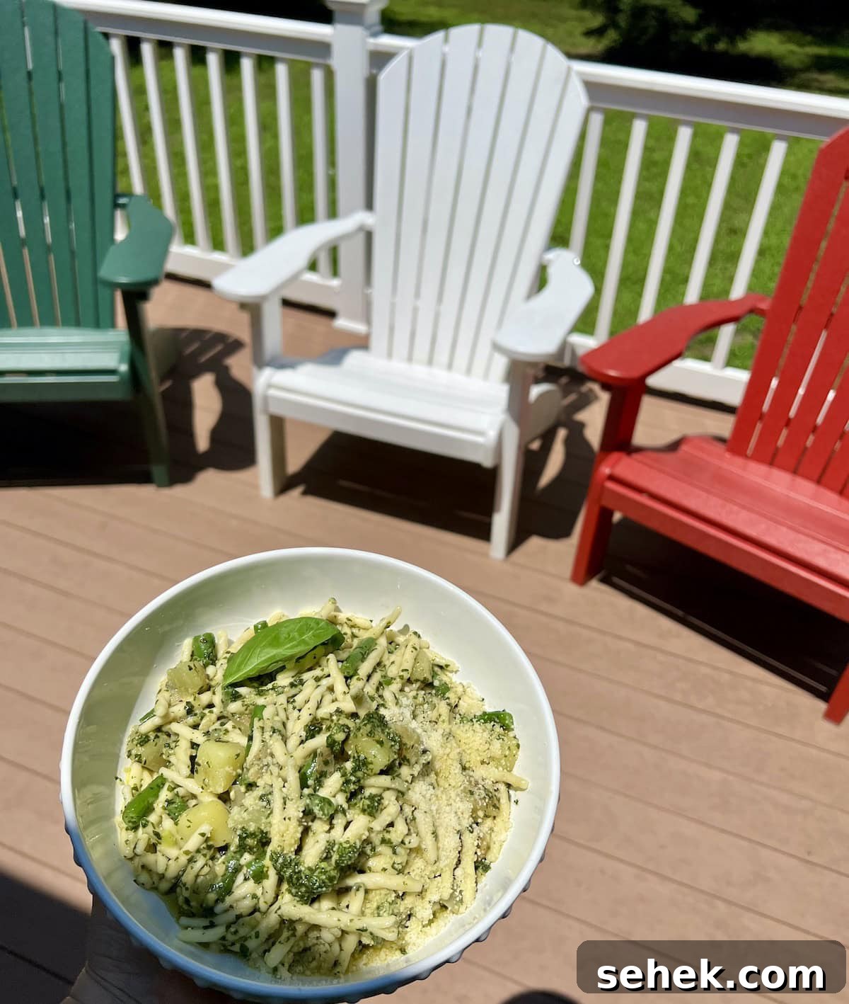 Trofie al Pesto Genovese with Potatoes and Green Beans 16 Bowl of Pasta with Pesto Green Beans and Potatoes with deck chairs in background.
