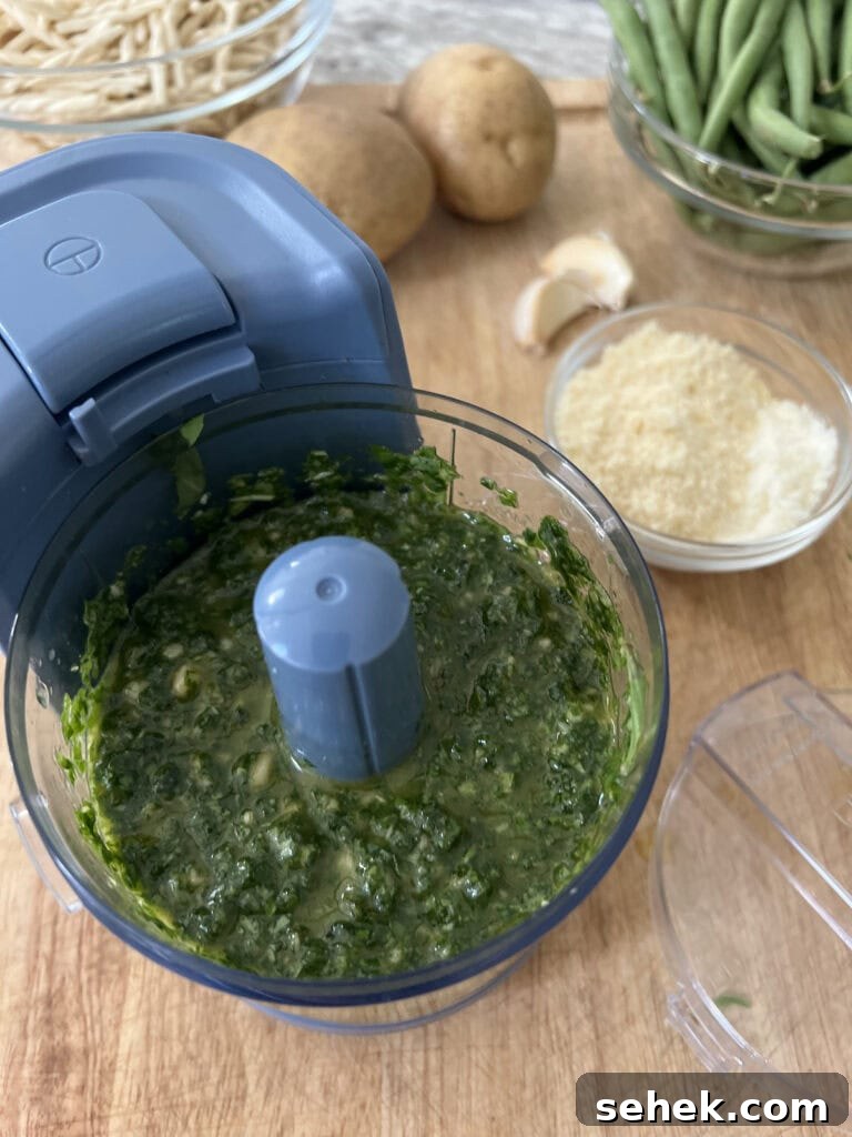 Trofie al Pesto Genovese with Potatoes and Green Beans 7 Finished basil pesto in food processor with other ingredients in background.