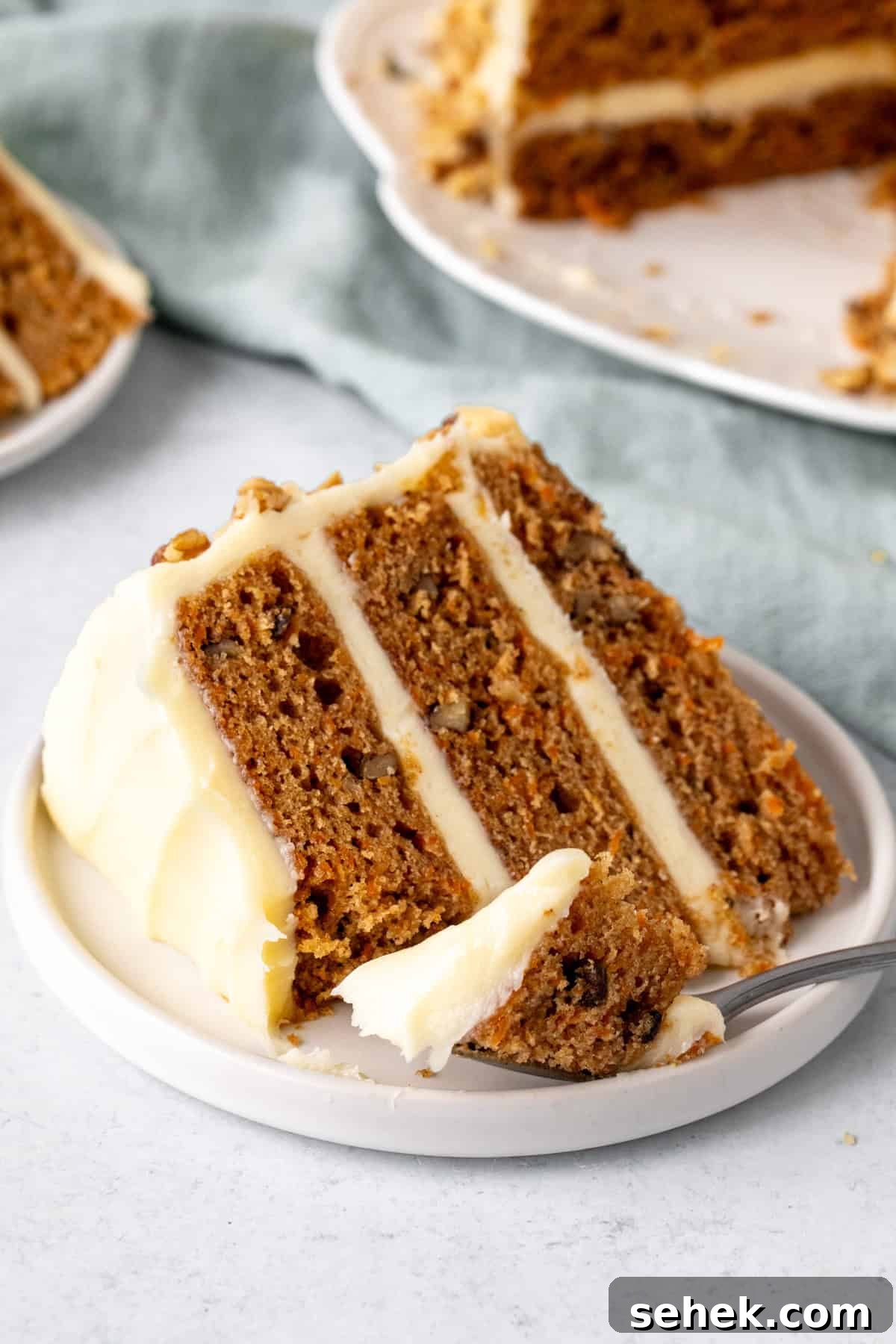 Layered Carrot Cake with Cream Cheese Frosting 8 Slice of carrot cake with a bite taken out.