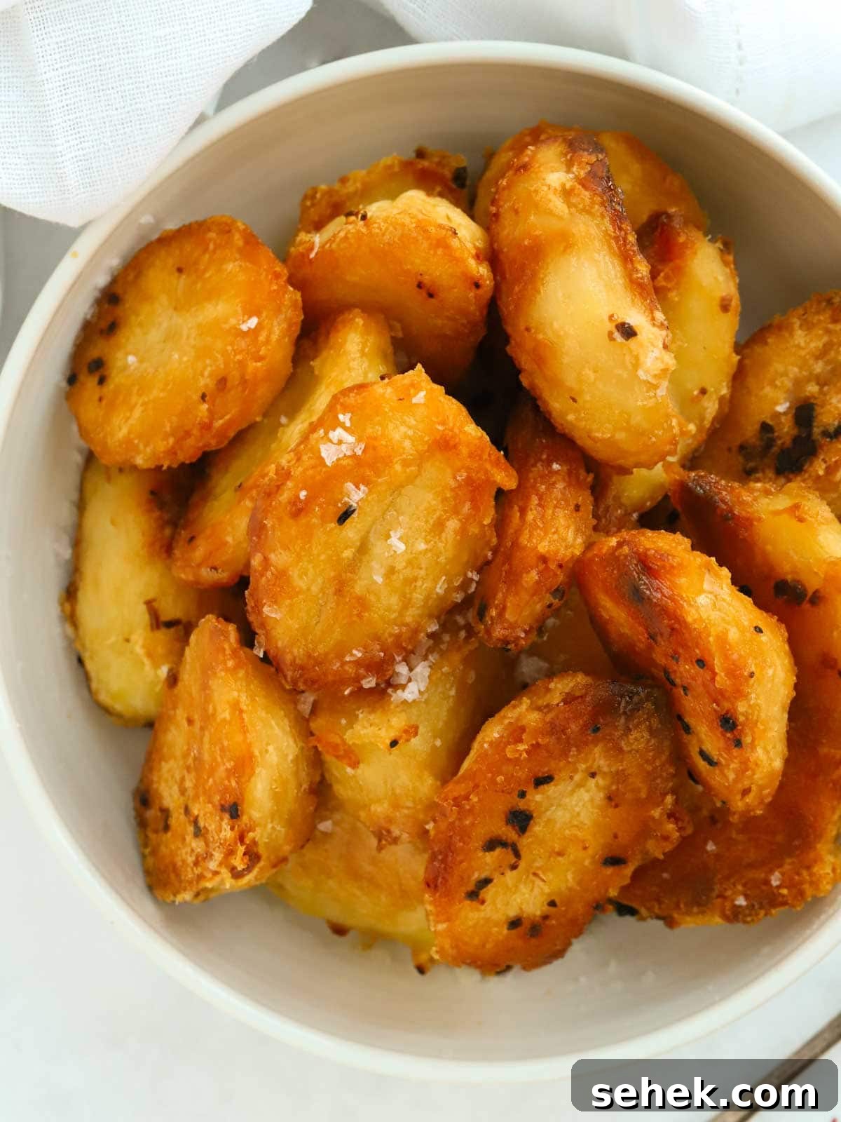 Crispy Roast Potatoes: Foolproof Oven Recipe for Golden Crunch 2 Close up of a bowl of delicious golden roast potatoes. This is an easy recipe.