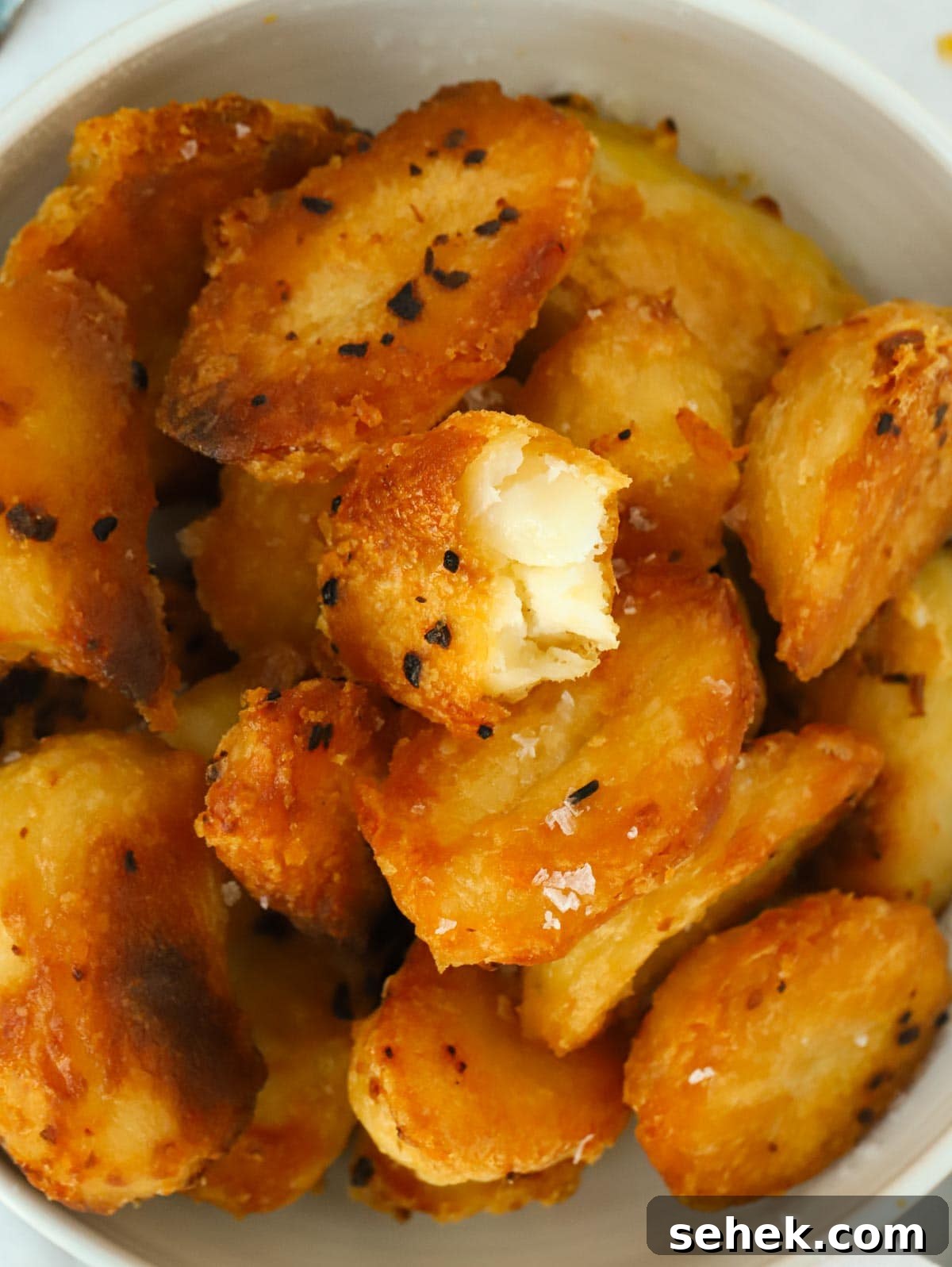 Crispy Roast Potatoes: Foolproof Oven Recipe for Golden Crunch 3 Big close up of a bowl of golden, crispy roast potatoes.