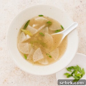 20+ Simple Vegan Soup Recipes for Every Season 22 a bowl of mu guk next to a plate of freshly sliced green onions